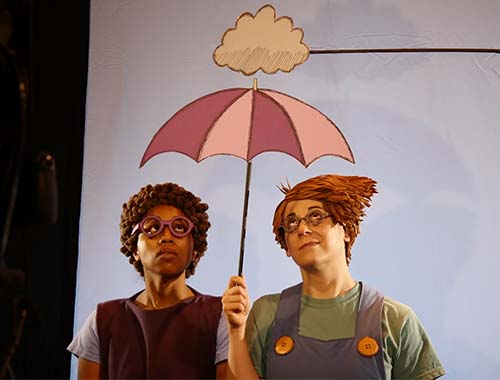 Image of two people standing close together under a colorful umbrella, sharing a moment in the rain.
